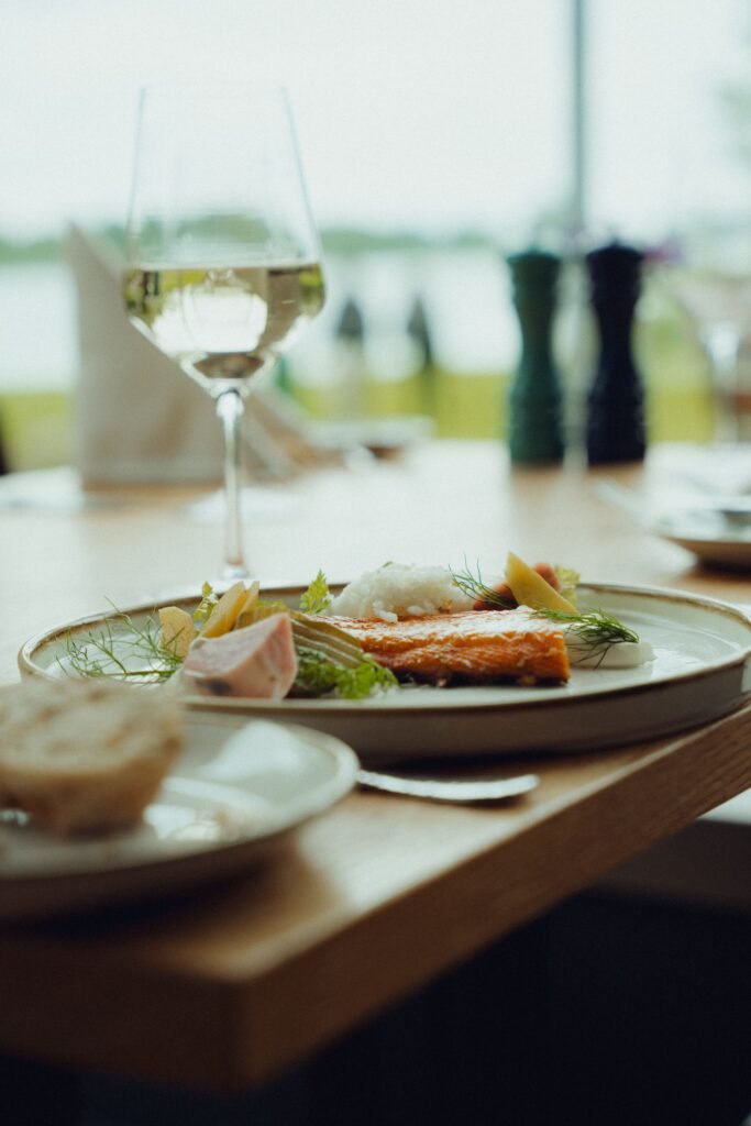 Ein Teller mit buntem Gemüse, gegrilltem Fisch und Reis. Auf der Haut gebratener Zander, Regionale Küche Schleswig-Holstein. Speisekarte Gasthaus Westensee